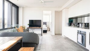A modern apartment with a living area, a kitchen, and a bedroom. - Cozy Bondi Apartment Heated Winter Stay (Bondi Beach)