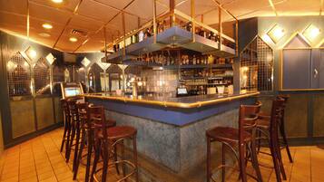 Enjoy a drink at the central bar, surrounded by shelves stocked with a selection of beverages.