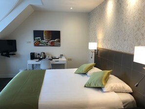 Relax in this stylish room with a neatly made bed, desk, and flat-screen TV.