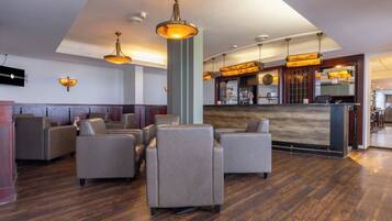 Relax in our welcoming lobby, featuring a central reception desk and comfortable seating area.