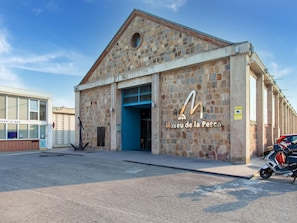A building with a stone facade and a blue door, labeled 'Museu de la Pesca'.