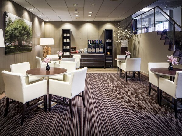 Guests can relax in the lobby's comfortable seating area, surrounded by artwork and a reception desk.