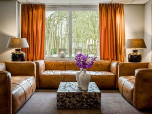 Relax in the living room with a comfortable sofa, coffee table, and two vases with flowers.