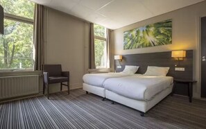 Relax in comfort with a large bed, bedside tables, and a cozy chair by the window.