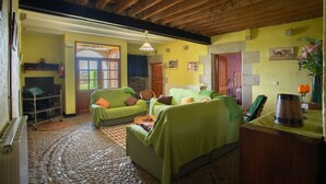 Una sala de estar acogedora con sofás verdes, una mesa de centro y una chimenea.
