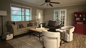 A living room with a sofa, armchairs, a coffee table, and a fireplace.