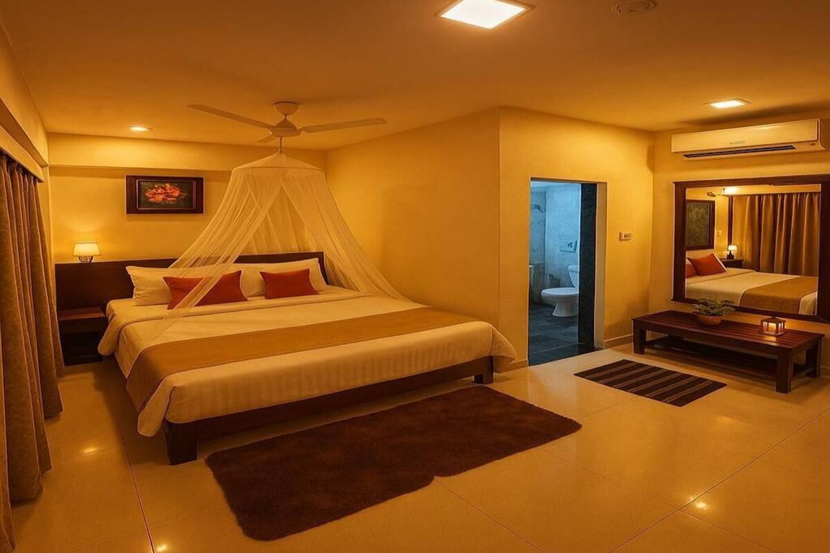 Quarto de hotel com cama, mesa de cabeceira e ventoinha no teto.