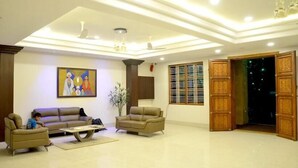 A spacious living room with a sofa set, a coffee table, and a painting on the wall.