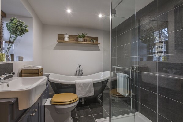 Un baño moderno con bañera, inodoro y zona de ducha.