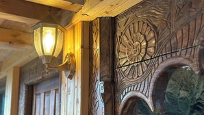 A wooden ceiling with a hanging lantern and ornate carved wooden panels.