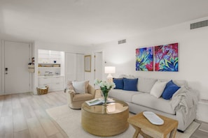 A modern living room with a sofa, coffee table, and decorative items.