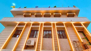 A multi-story building with balconies and a central air conditioning unit. - Hotel Vijay Deluxe (Sultanpur)