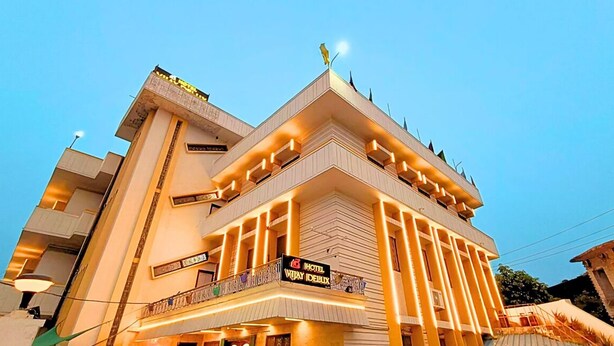 A multi-story hotel with a modern design, featuring balconies and a prominent sign for 'Hotel Vijay Idealux'. - Hotel Vijay Deluxe (Sultanpur)