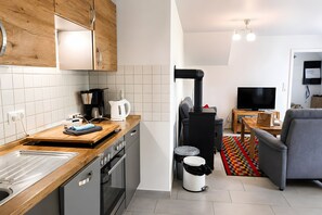 A modern kitchen with wooden cabinets, a built-in oven, and a coffee maker.