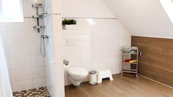 Ein modernes Badezimmer mit Dusche, Toilette und Ablagefläche.