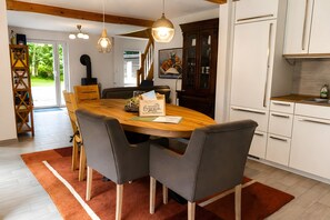 Un comedor con una mesa de madera, sillas grises y un tapete rojo.