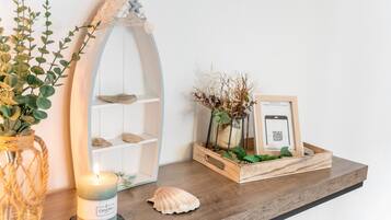 A wooden shelf with a candle, a seashell, and a framed photo.