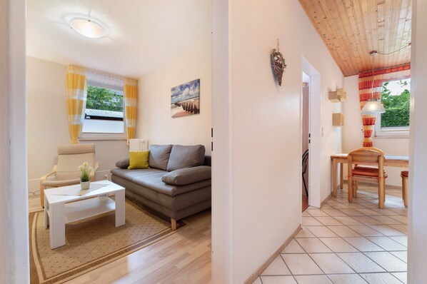 Un salon avec un canapé, une table basse et un tableau accroché au mur.