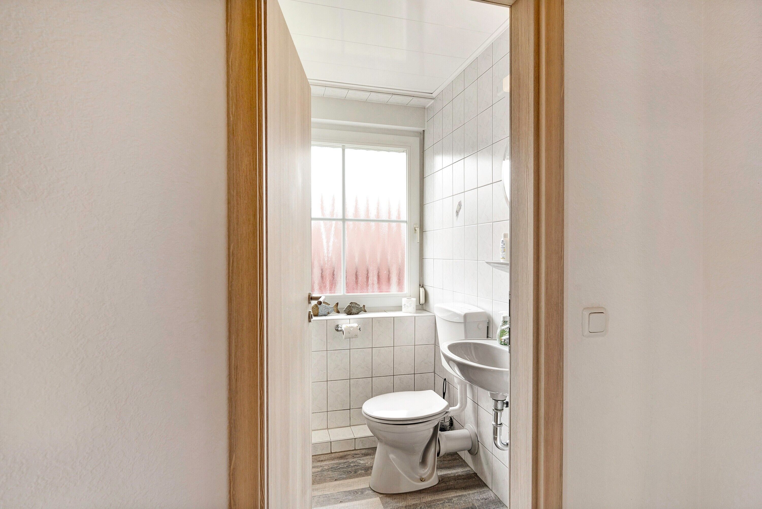 Un bagno con il water, un lavandino e una finestra.