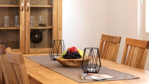 A wooden dining table with chairs, a fruit bowl, and two candle holders. - Apartment 'Blum' with Private Terrace, Garden, and Wi-Fi (Schmallenberg)