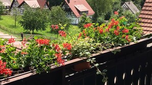 A view of traditional half-timbered houses with a garden in the foreground. - Klaus and Erika Köninger: Apartment 'Klaus' with Shared Garden and Wi-Fi (Sasbachwalden)