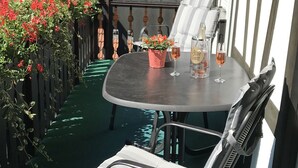 A round table with a chair, a potted plant, and a bottle of alcohol. - Klaus and Erika Köninger: Apartment 'Klaus' with Shared Garden and Wi-Fi (Sasbachwalden)