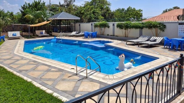 Una piscina con lettini e una piccola statua.