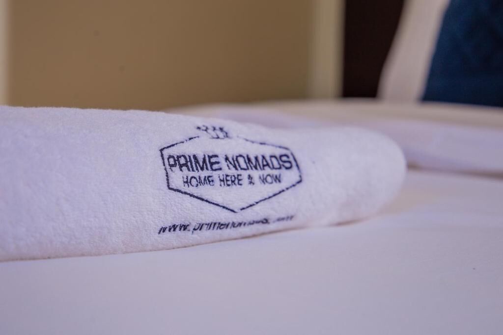A rolled-up towel with a logo and text indicating it is from Prime Nomads.