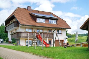A two-story house with a red slide, a balcony, and solar panels on the roof. - Apartment 'Vogelsang' with Shared Garden, Balcony and Wi-Fi (St Peter)
