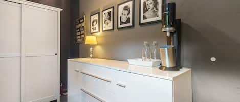 Un baño moderno con tocador blanco, espejo y grifo de pared.