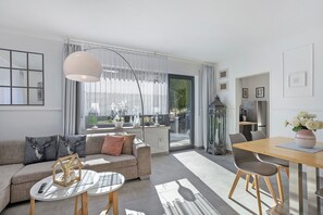A modern living room with a sofa, coffee table, and dining area. - Apartment 'Riekes' with Mountain View, Private Terrace and Wi-Fi (Schmallenberg)
