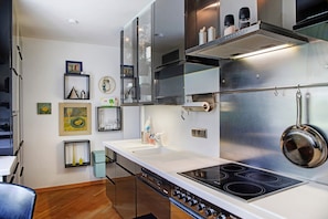 A modern kitchen with stainless steel appliances, a double sink, and a range hood. - Haus Gutschi with Mountain Views, Large Garden and Wi-Fi (Gemeinde Imst)