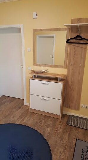 Une chambre à coucher avec un lit, une commode, un miroir et une armoire.