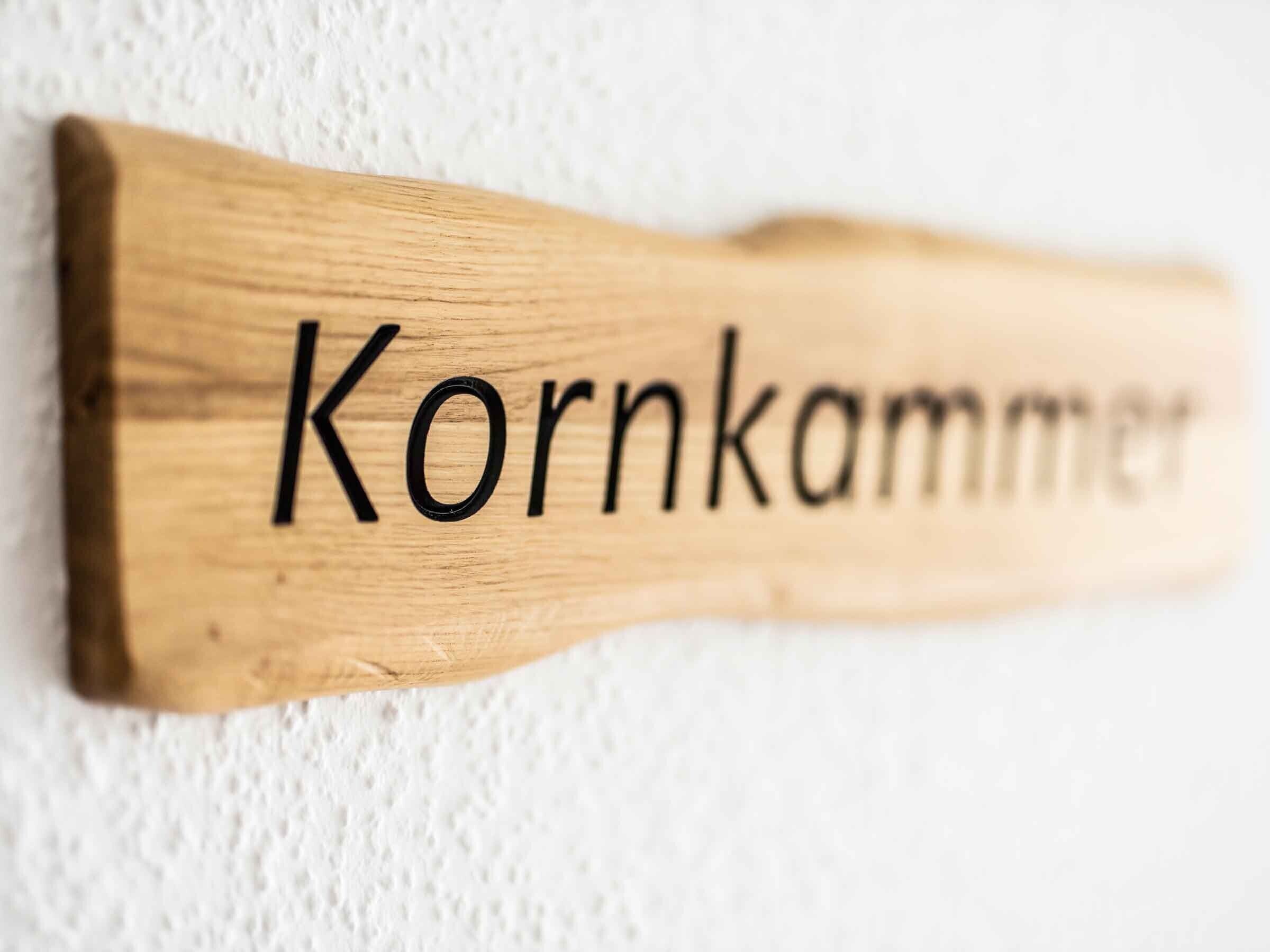 A wooden sign with the word 'Kornkammer' on it.
