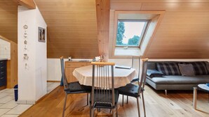A cozy room with a dining table, chairs, a sofa, a window, and a wooden ceiling. - Apartment 'Schweizer' with Mountain View, Balcony and Wi-Fi (Bernau im Schwarzwald)