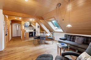 Un vaste espace de vie de style loft comprenant un coin repas, une cuisine et un coin salon.