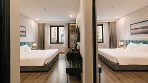 Een hotelkamer met twee bedden, een bureau en een spiegel.