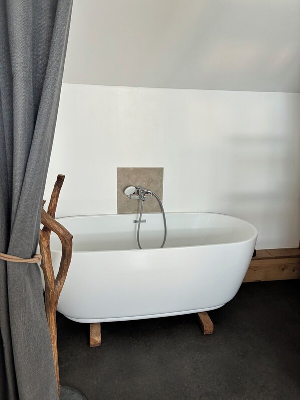 A modern bathroom with a freestanding bathtub, wooden legs, and a towel rack. - Aube du Morvan, charming family home (Dompierre-en-Morvan)