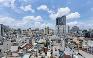 Un'area urbana densamente popolata con diversi tipi di edifici, tra cui grattacieli e strutture più basse, sotto un cielo parzialmente nuvoloso.