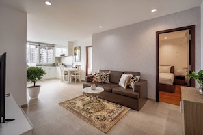 A modern living room with a sofa, coffee table, and a potted plant.
