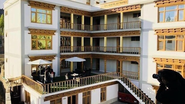 Een meerlaags gebouw met een centrale binnenplaats, balkons en buiten zitgedeeltes.