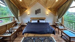A high-ceilinged room with a large bed, wooden furniture, and a view of greenery outside. - Crimson inn by Senderos De Pine (Kullu)