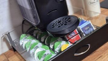Eine Küchenzeile mit einer Bosch-Kaffeemaschine, einer Schublade voller Getränke und einem Utensilienhalter.