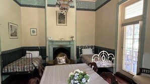 A dining room with a long table, chairs, a chandelier, a fireplace, and a large window. - Cosy and comfortable riverside homestead in Bridgetown - sleeps up to 14 guests. (Bridgetown)