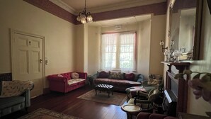 A living room with a fireplace, two sofas, a coffee table, and a patterned rug. - Cosy and comfortable riverside homestead in Bridgetown - sleeps up to 14 guests. (Bridgetown)
