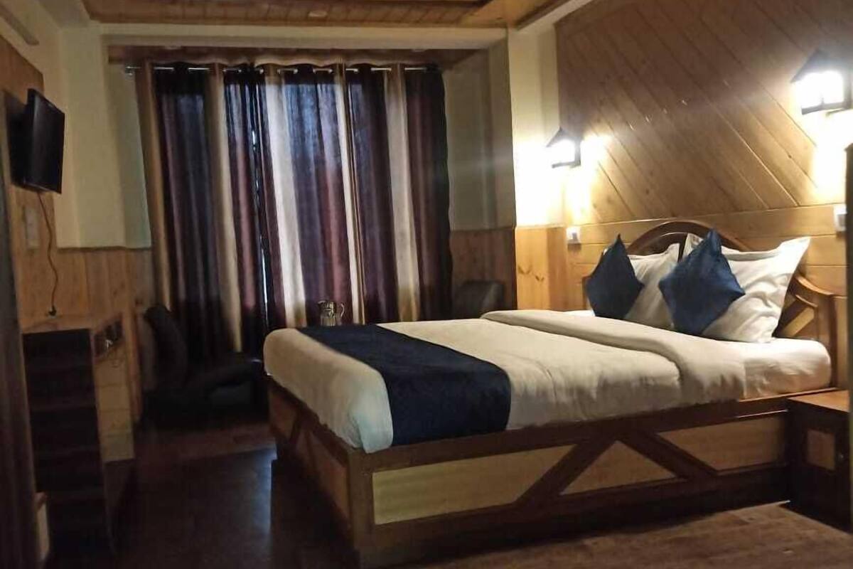 A wooden-paneled room with a bed, a chair, and a television.
