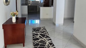 Un interior moderno con un escritorio de madera, un tapete blanco y negro y una araña.