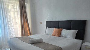 Un dormitorio moderno con una cama grande, una mesita de noche y una alfombra mullida.