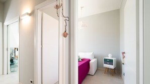 A modern bathroom with a white vanity, a pink bath mat, and a small bedside table with a lamp. - Villa Rossini with swimming pool - My Rental Homes (Custonaci)