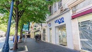 A street with a V&O store, a tree, and a pedestrian walkway.